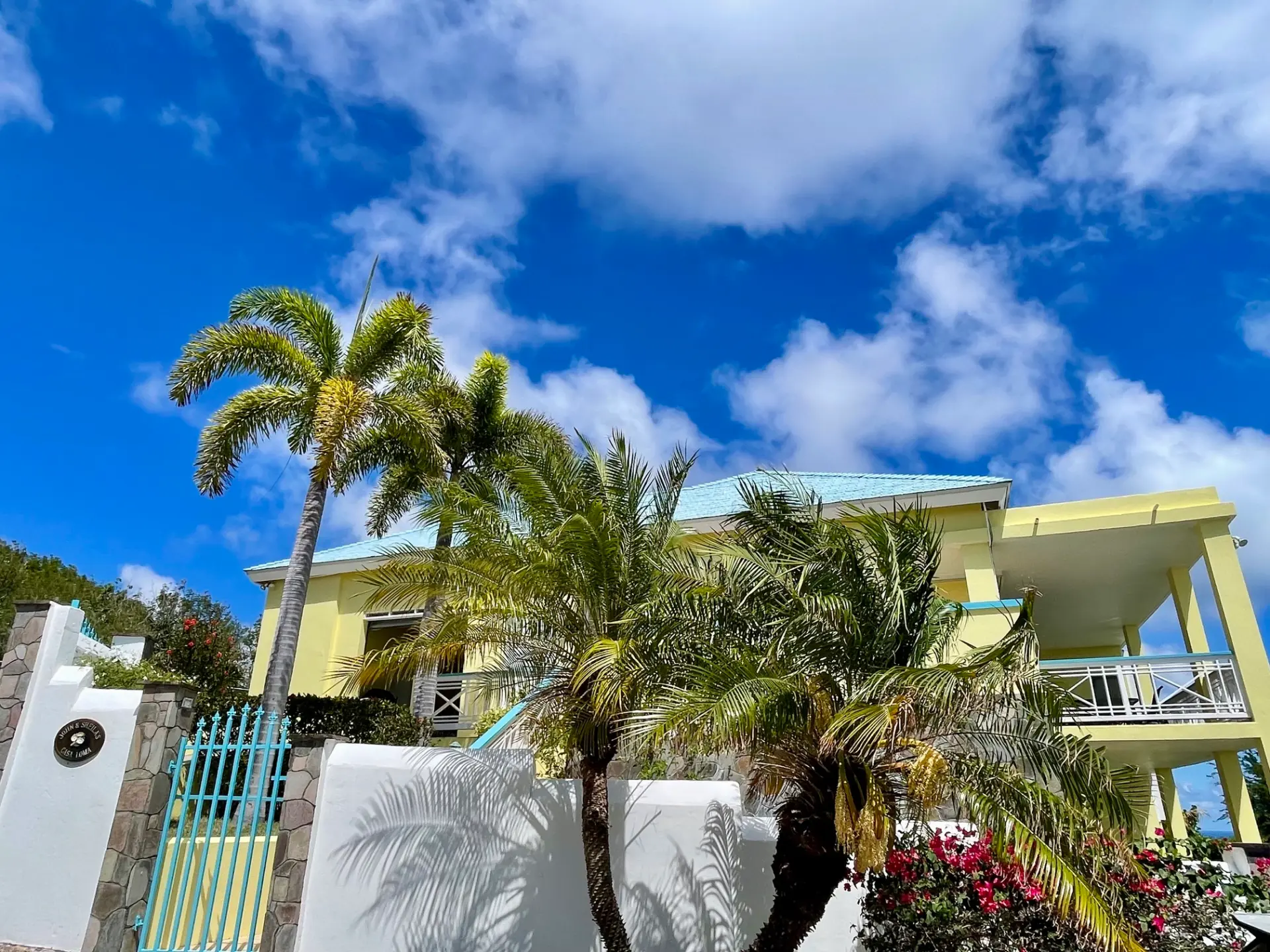 Front gardens with royal palms and gated entrance