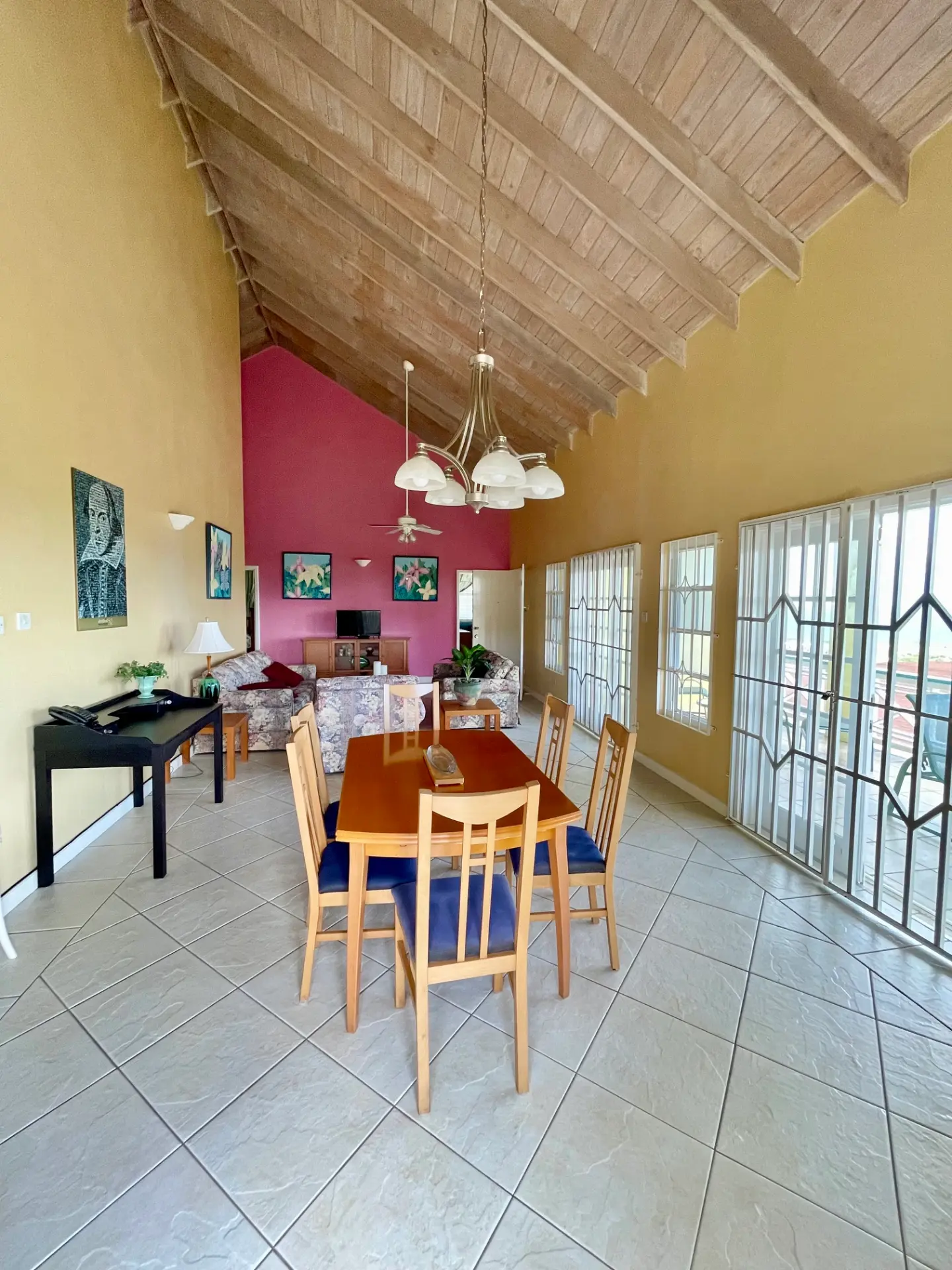 Open living and dining room with vaulted wood ceiling
