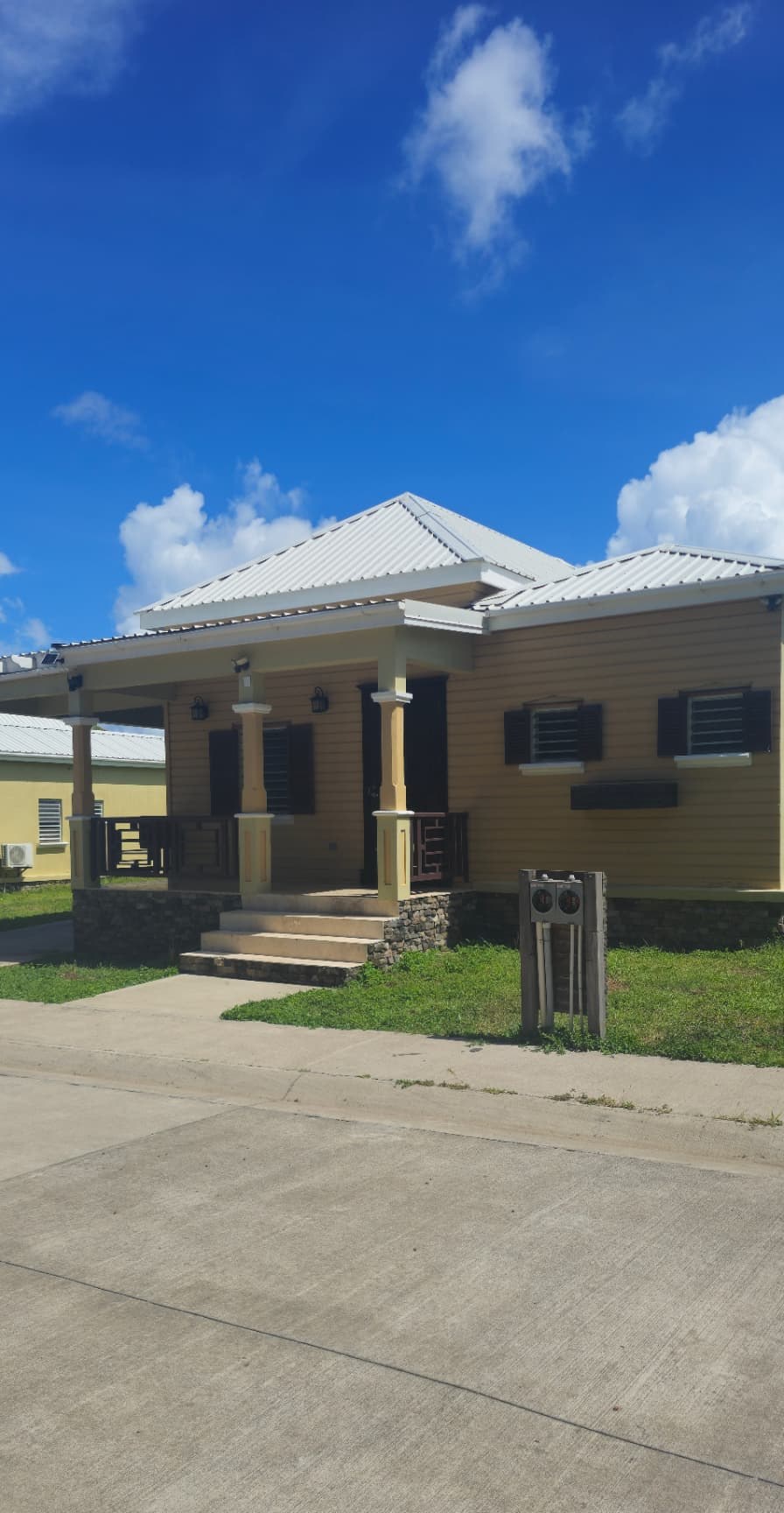Single-storey home with a covered front porch, stone-clad base and louvered shutters